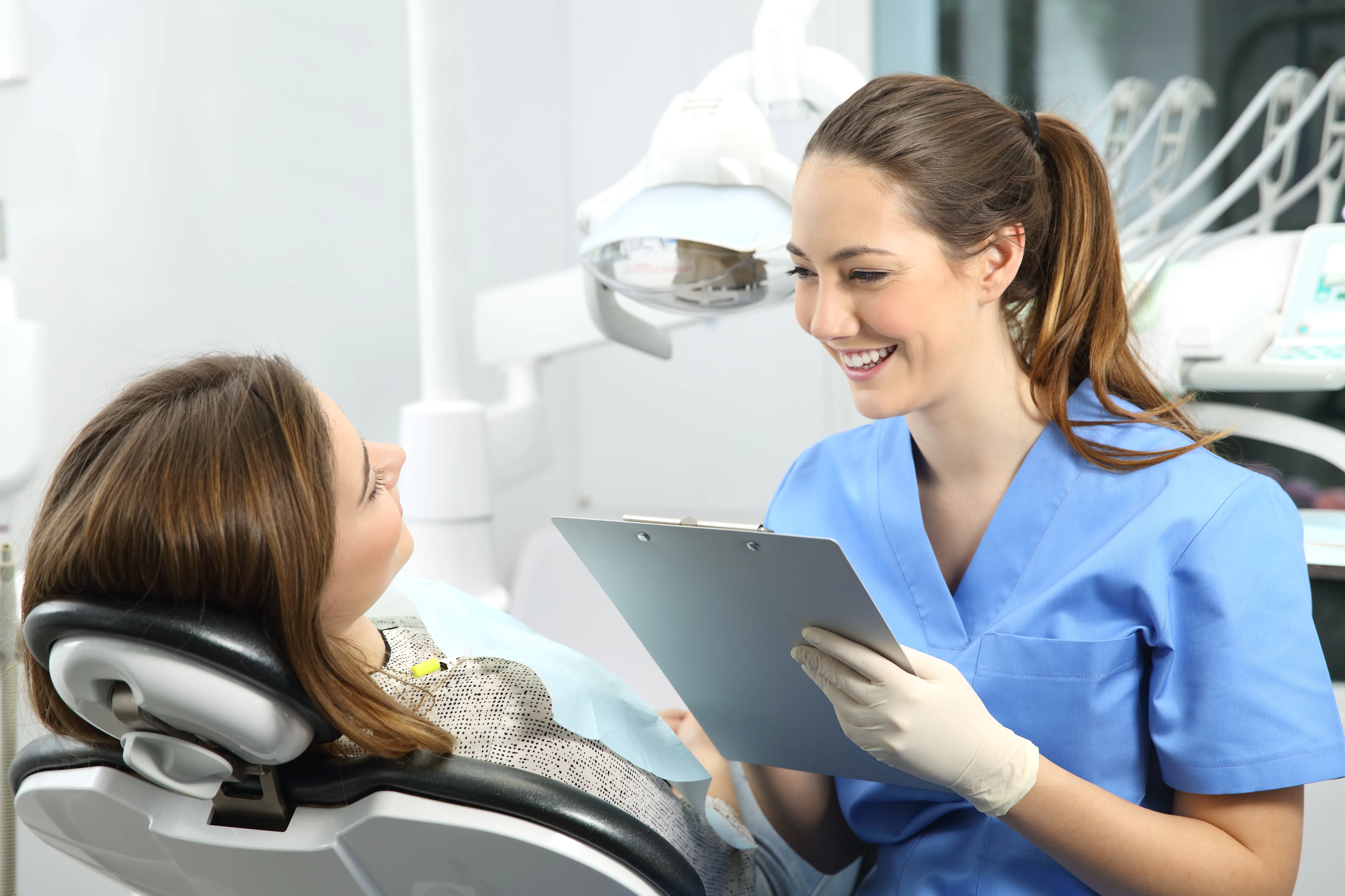 A dentist in conversation with a patient in a bright treatment room